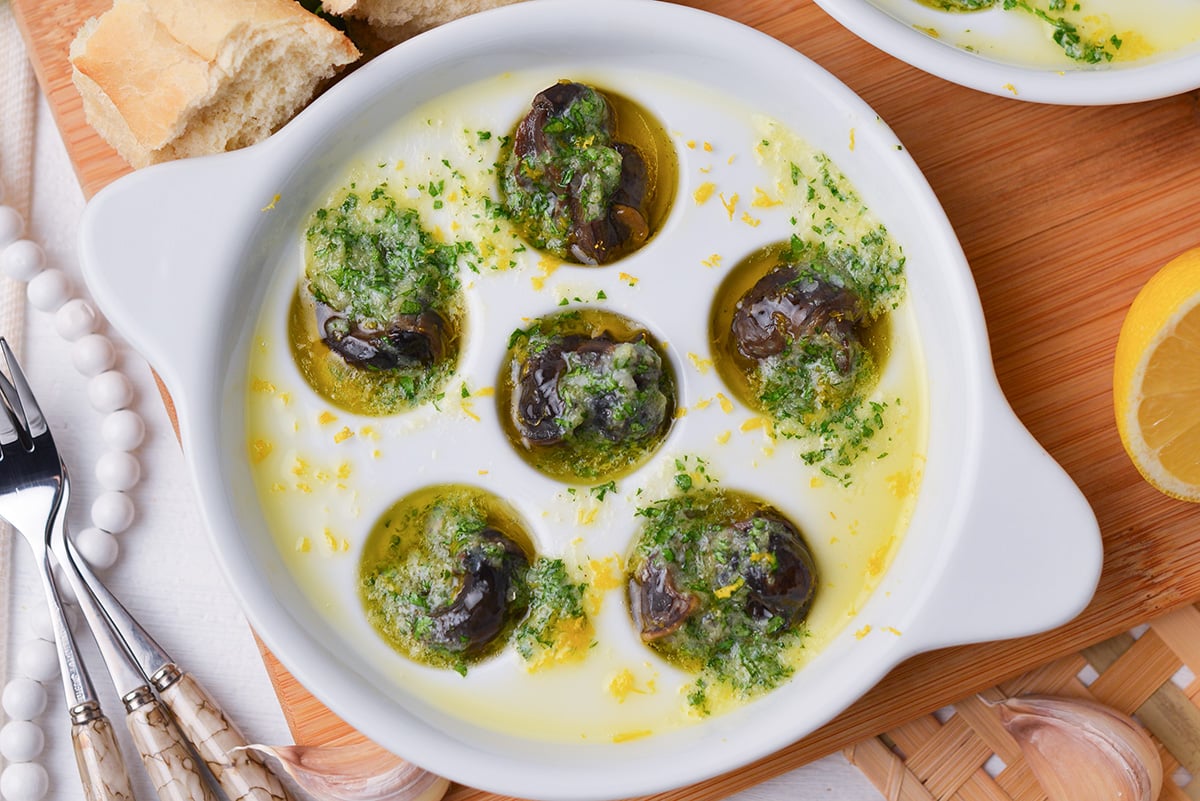 close up of snails in garlic butter in an escargot dish