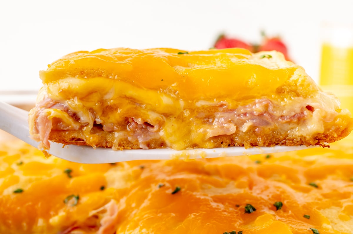 straight on shot of slice of ham and cheese casserole on spatula