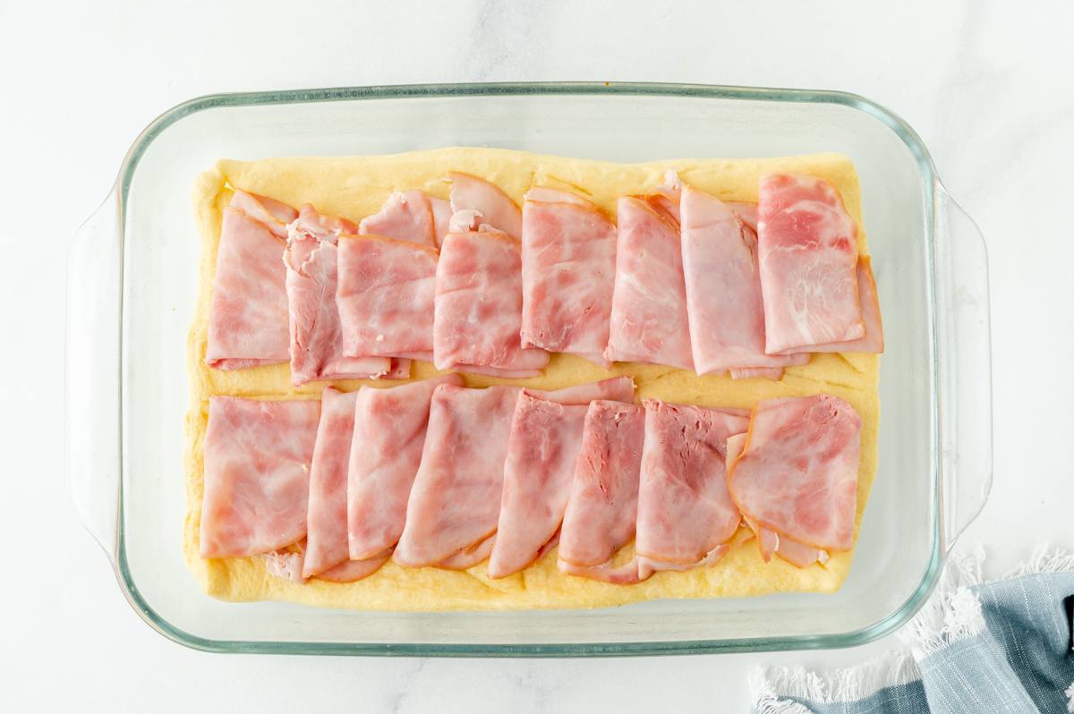 overhead shot of slices of ham on crescent dough