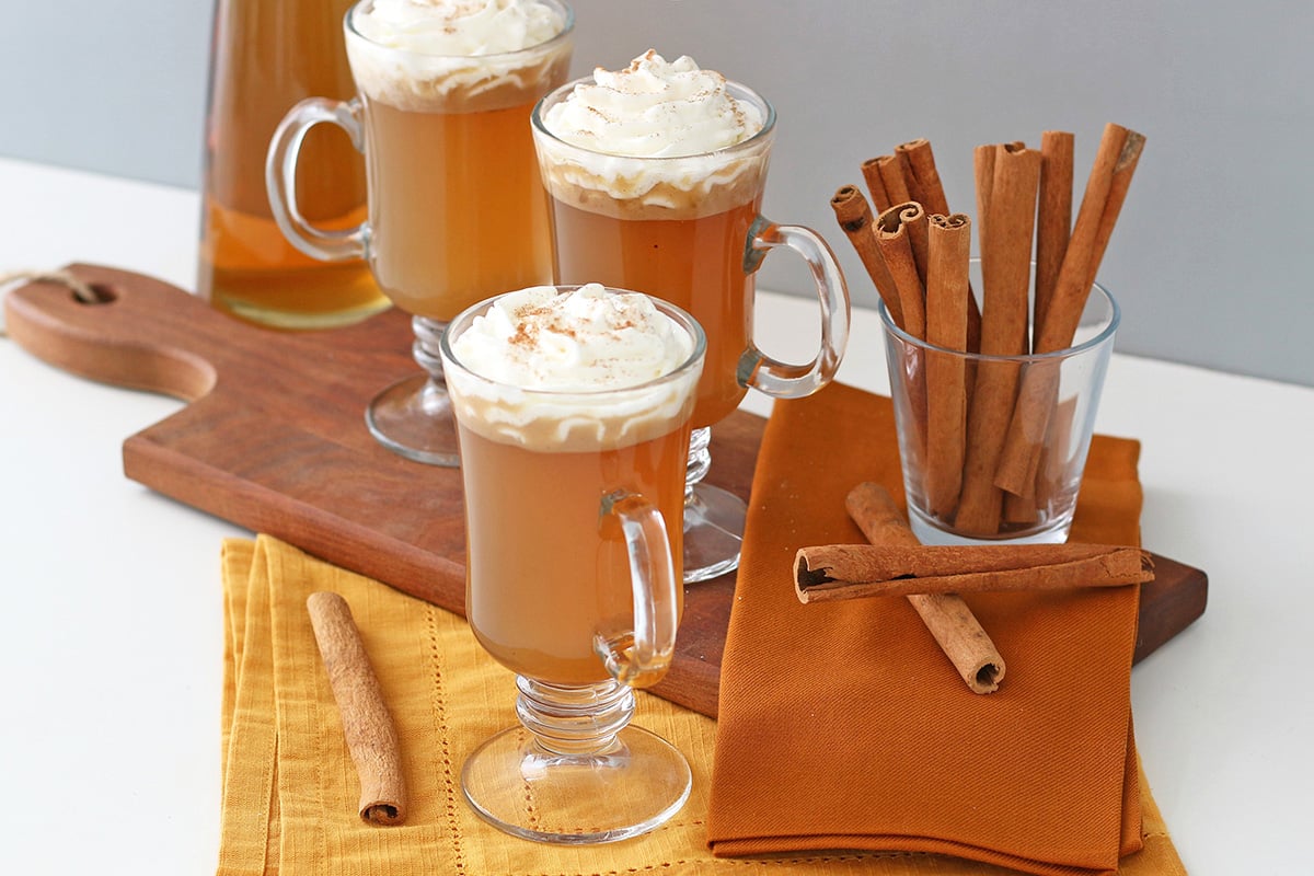 Cups of hot buttered rum and cinnamon sticks