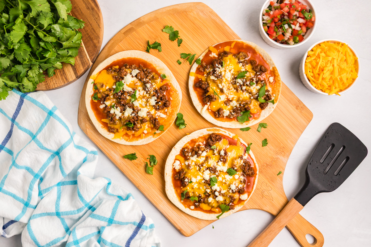 overhead shot of three mexican pizzas on wooden board
