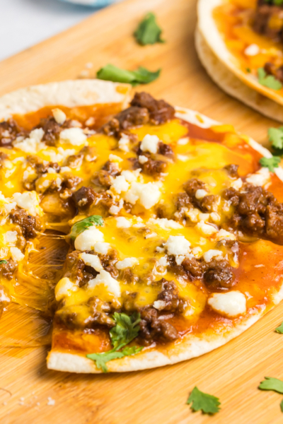 hand taking slice of tortilla pizza