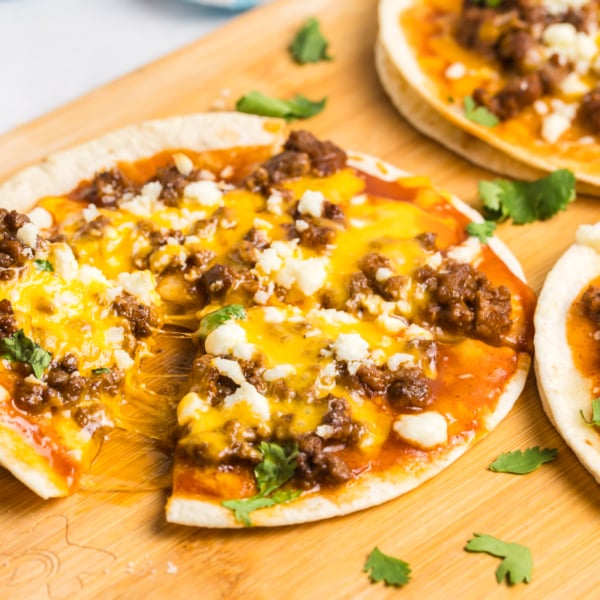 hand taking slice of tortilla pizza