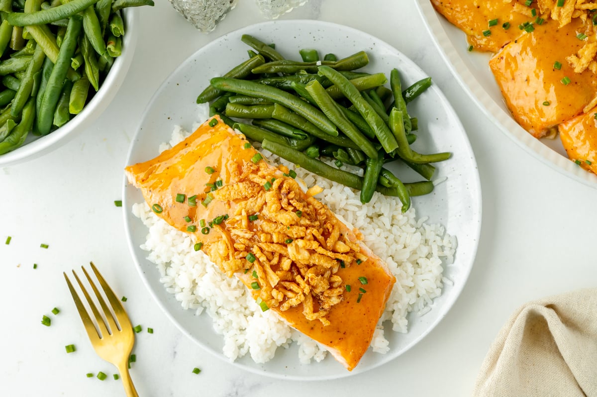 overhead shot of plate of bbq baked salmon with rice and green beans