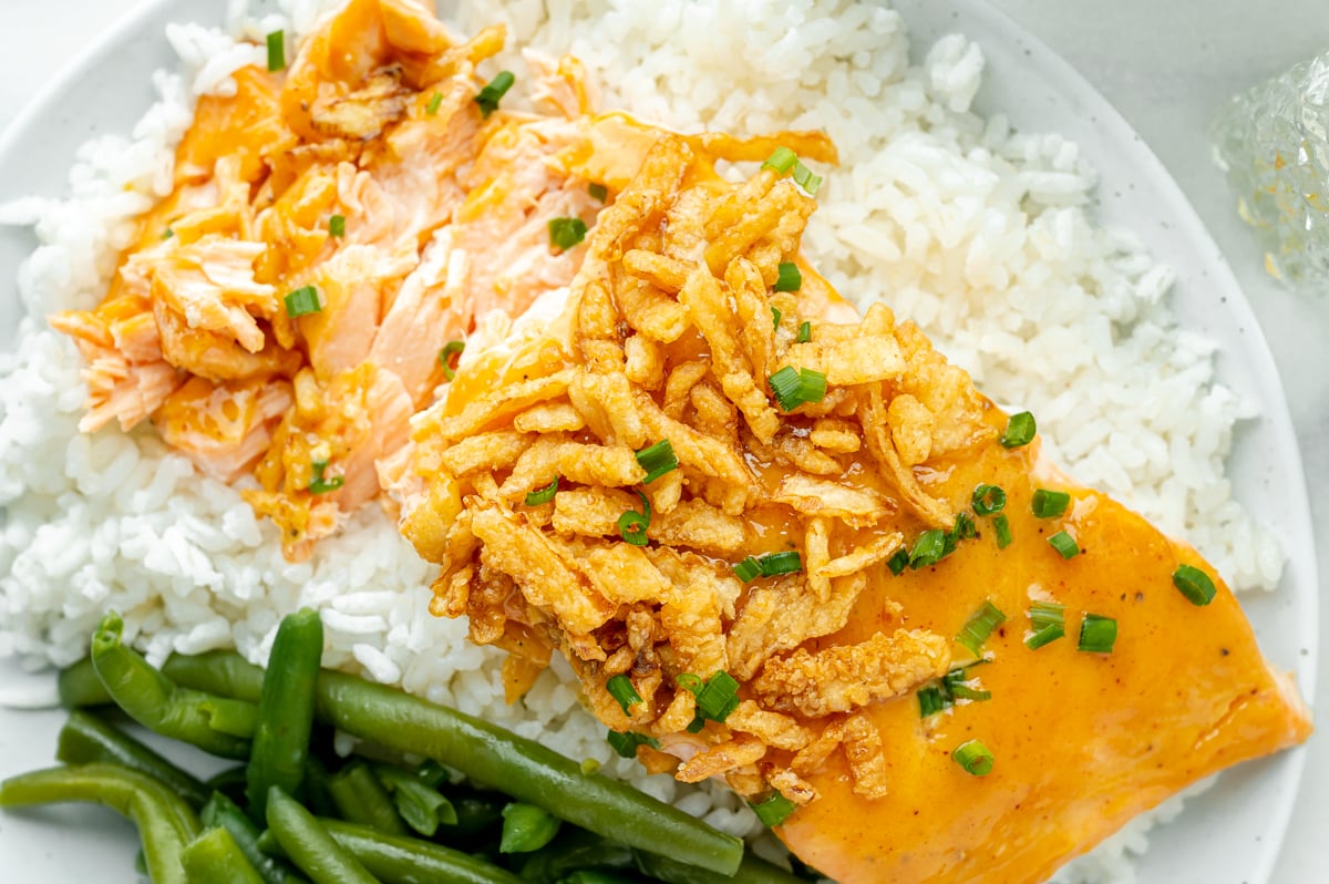 close up overhead shot of bbq baked salmon over rice with green beans