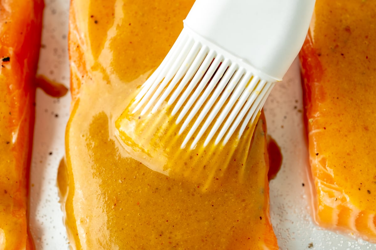 brushing sauce on salmon
