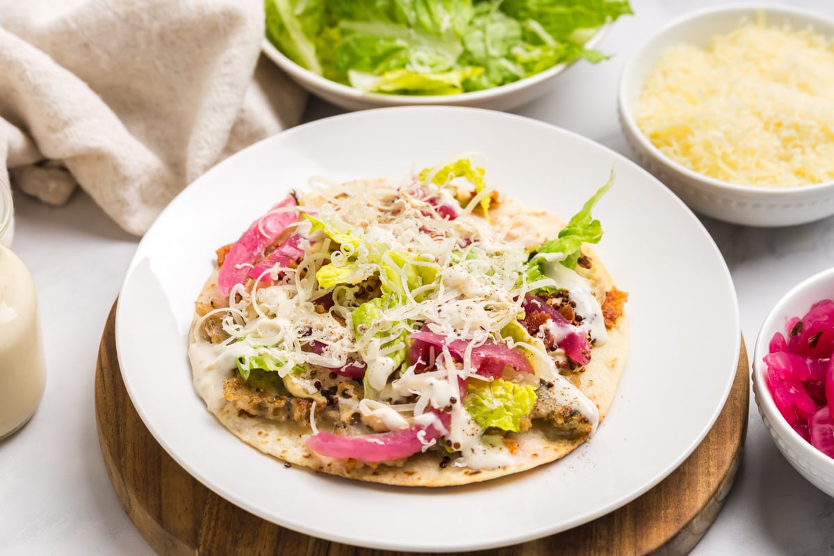 angled shot of chicken caesar smash taco on plate