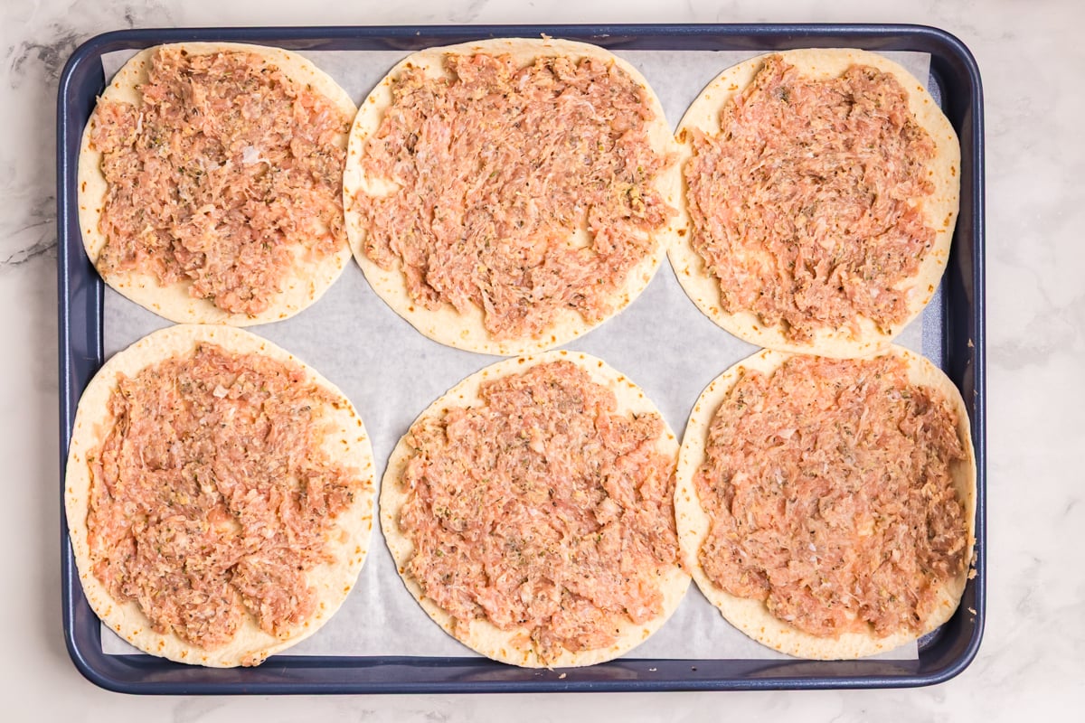 overhead shot of ground chicken pressed onto tortillas