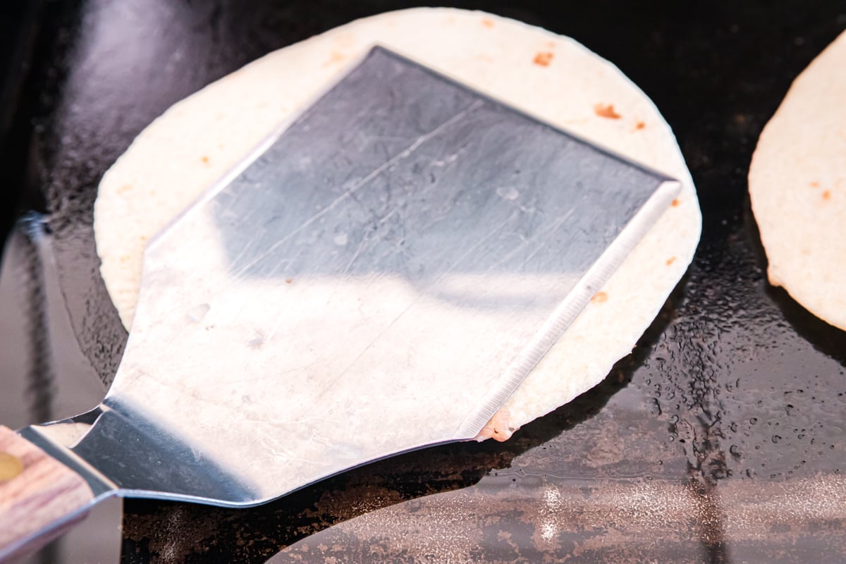 spatula pressing own on a smash tacos