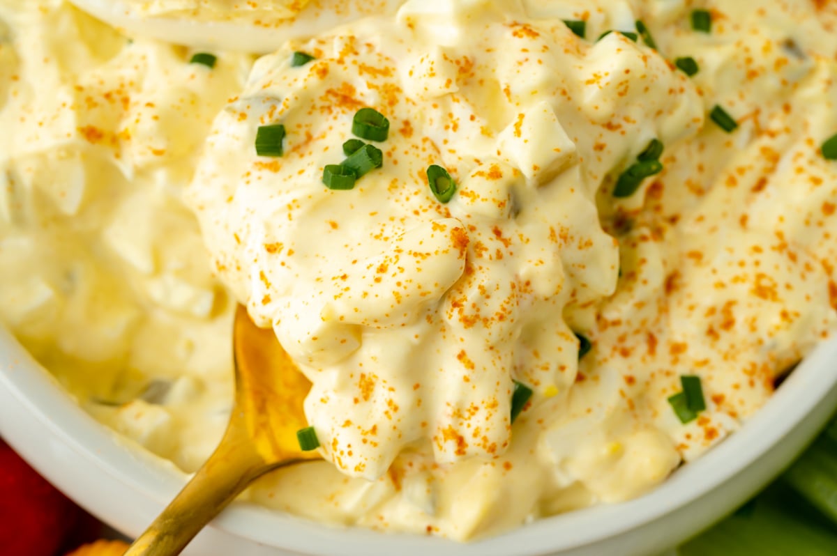 close up shot of spoon in bowl of deviled egg dip
