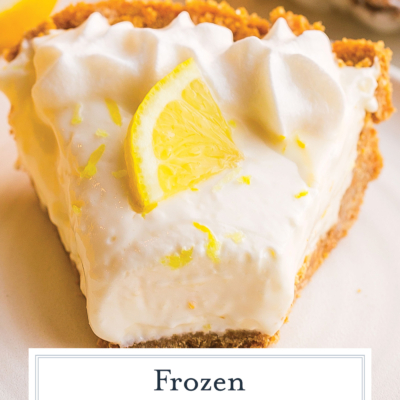 angled shot of bite taken out of slice of frozen lemonade pie on plate with text overlay