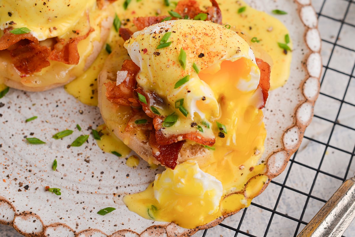 close up of hollandaise sauce over eggs benedict