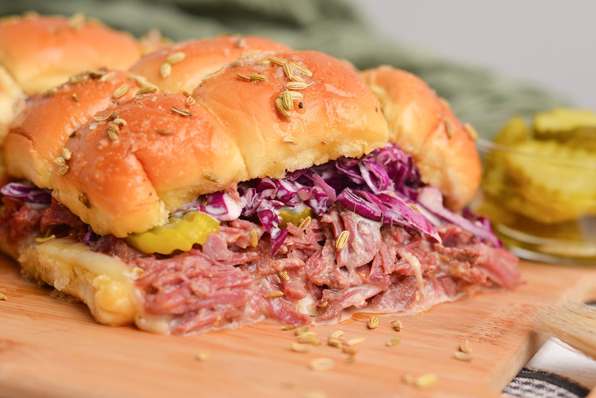 angle view of leftover corned beef and red cabbage slaw falling out of a slider sandwich roll