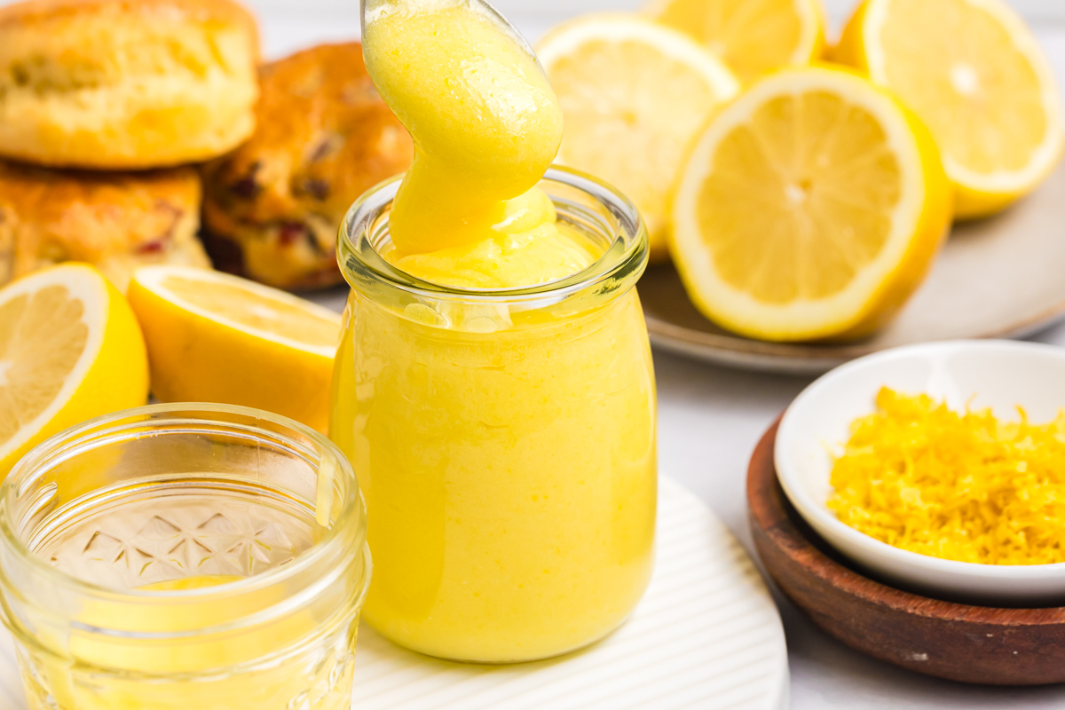 spoon adding lemon curd to jar