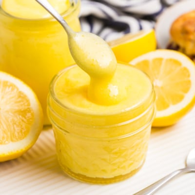 spoon dipping into jar of lemon curd
