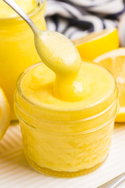 spoon dipping into jar of lemon curd