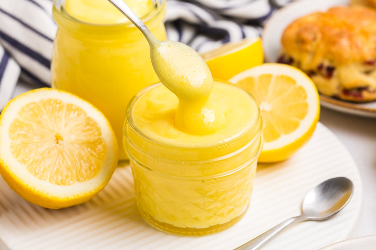 spoon dipping into jar of lemon curd