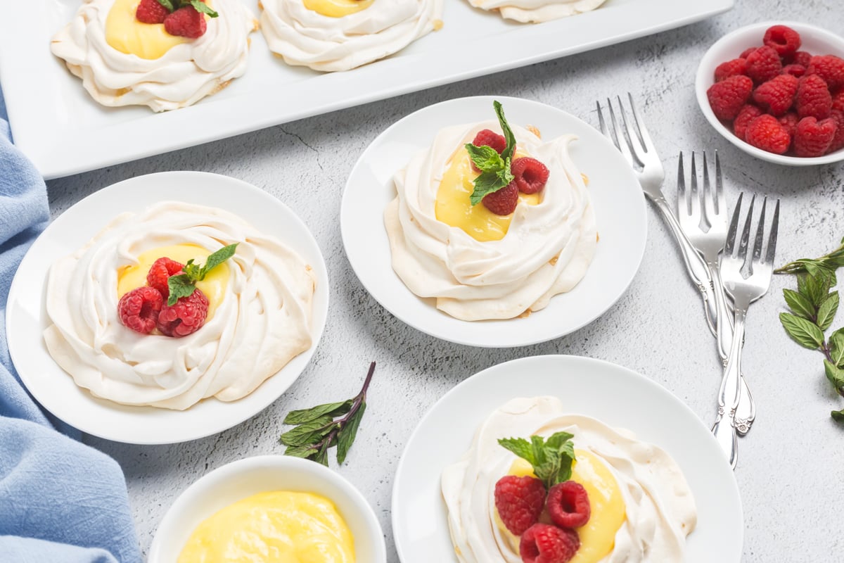 angled shot of plates of lemon curd meringues