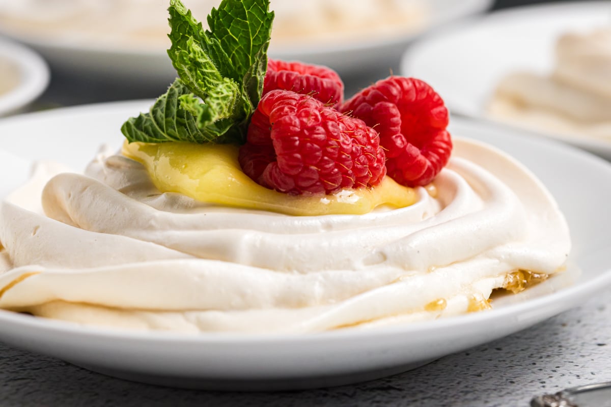 close up shot of mini pavlova with lemon curd and raspberries