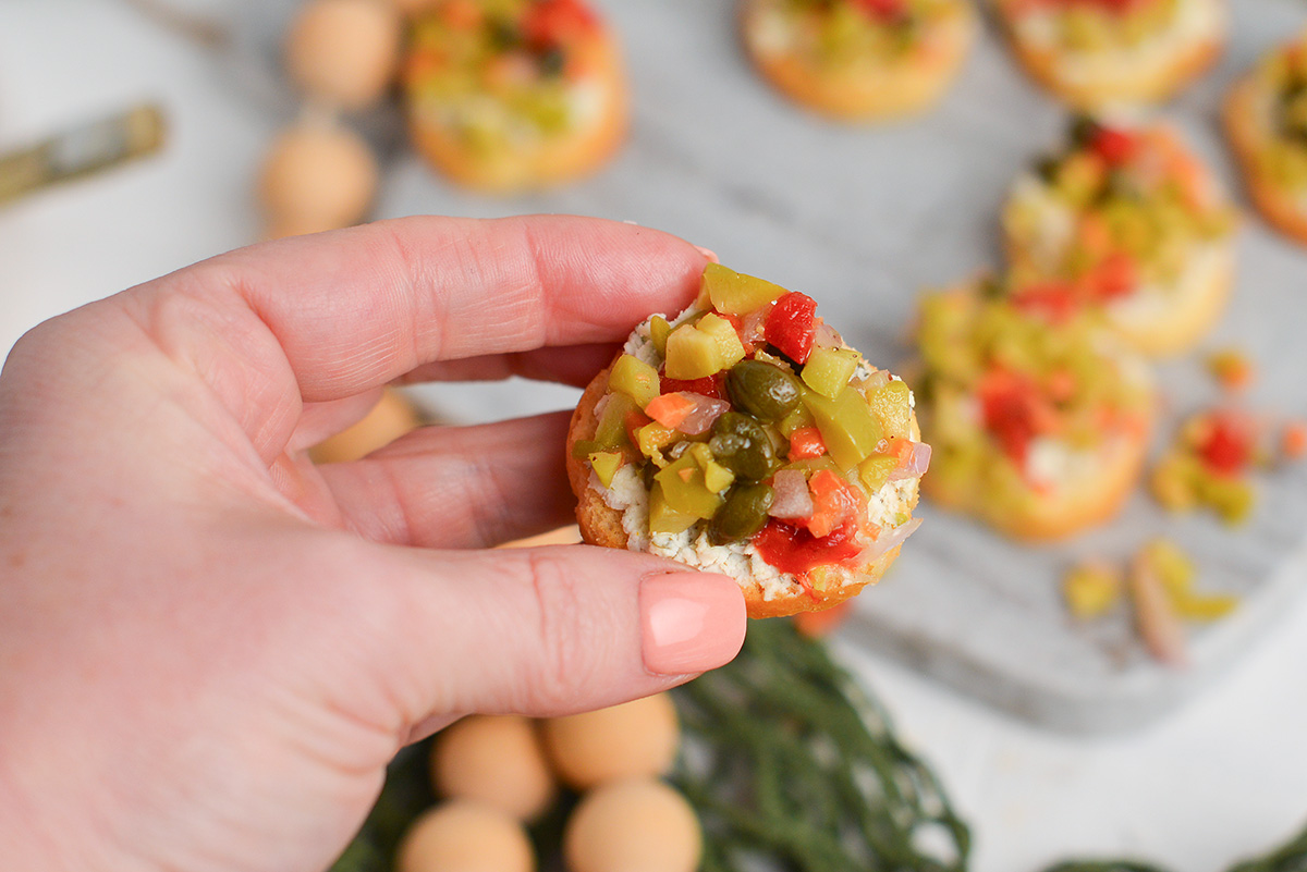 hand holding green olive appetizer