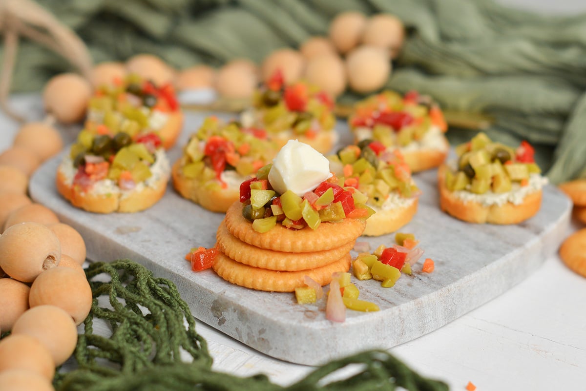 stack of round crackers with olive tapenade and mozzarella cheese ball