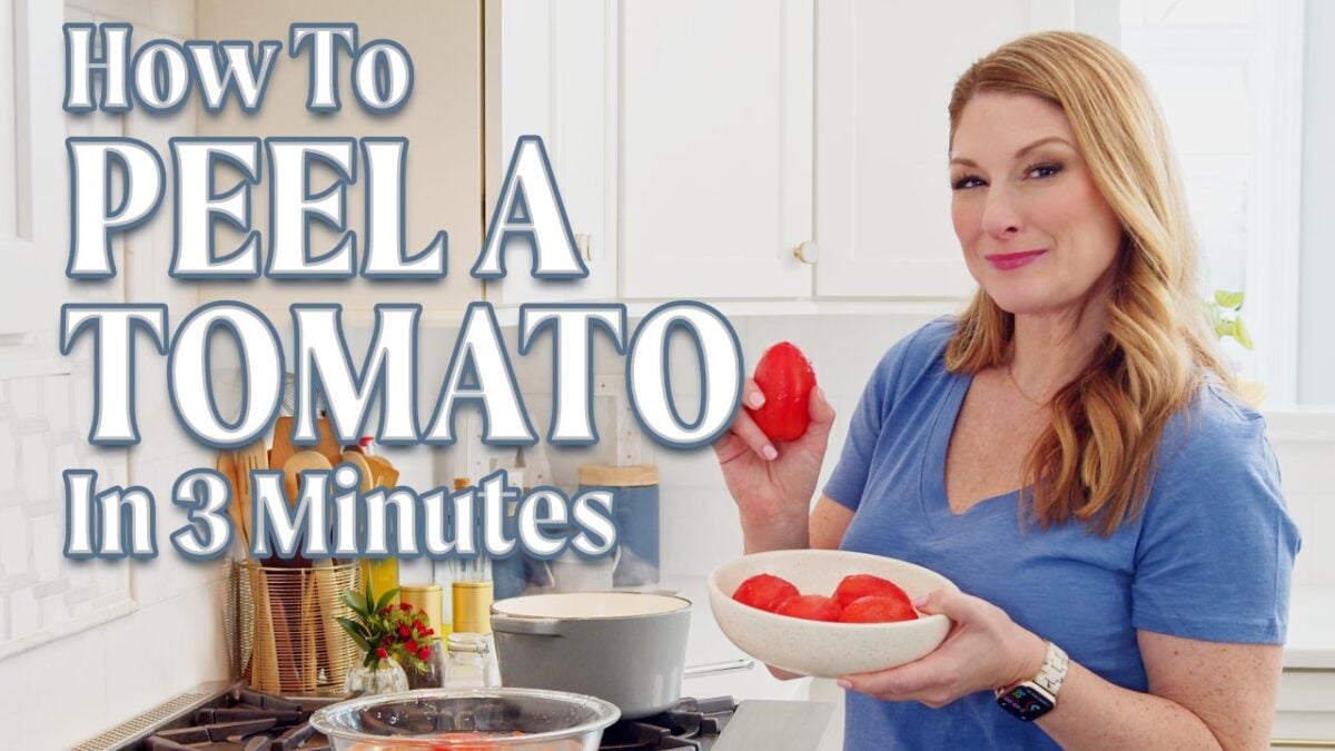 jessica showing a peeled roma tomato in her kitchen