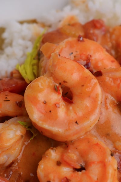 close up of gently curled shrimp in a creole sauce