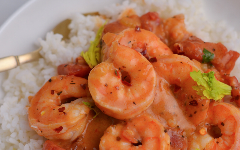 close up of gently curled shrimp in a creole sauce