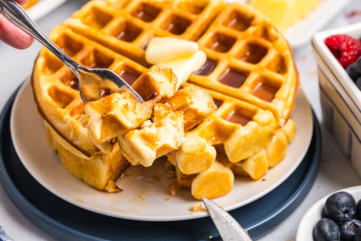 fork taking a bite of stack of homemade waffles