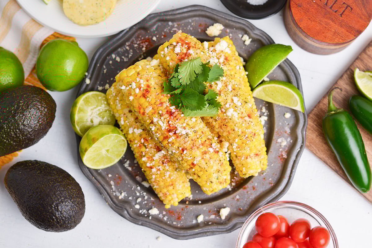 overhead shot of plate of corn on the cob with seasonings