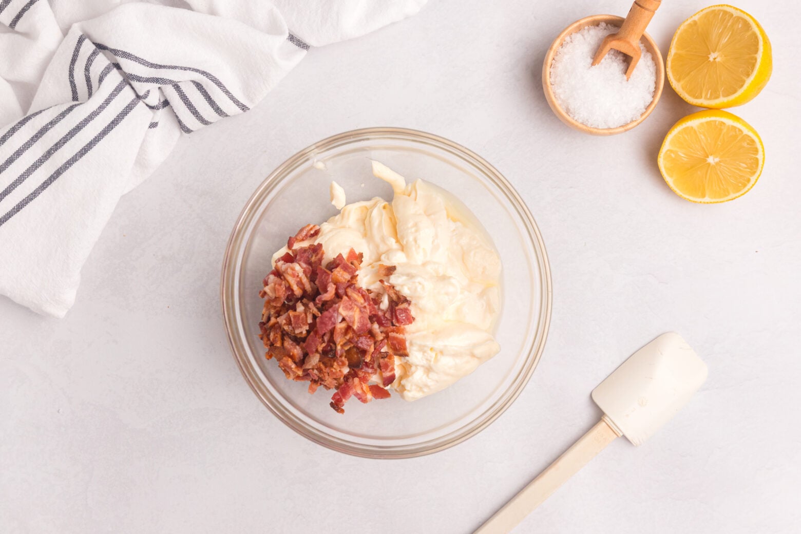 bacon aioli in small bowl with crispy bacon on top