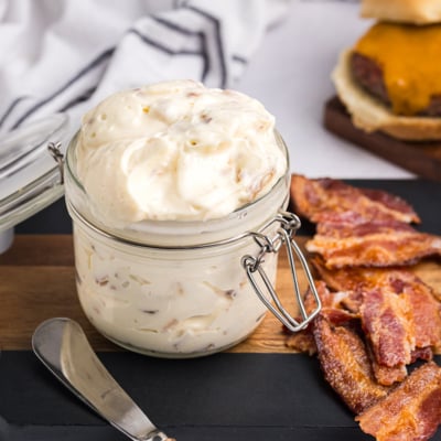 angled shot of bacon aioli on cutting board with bacon