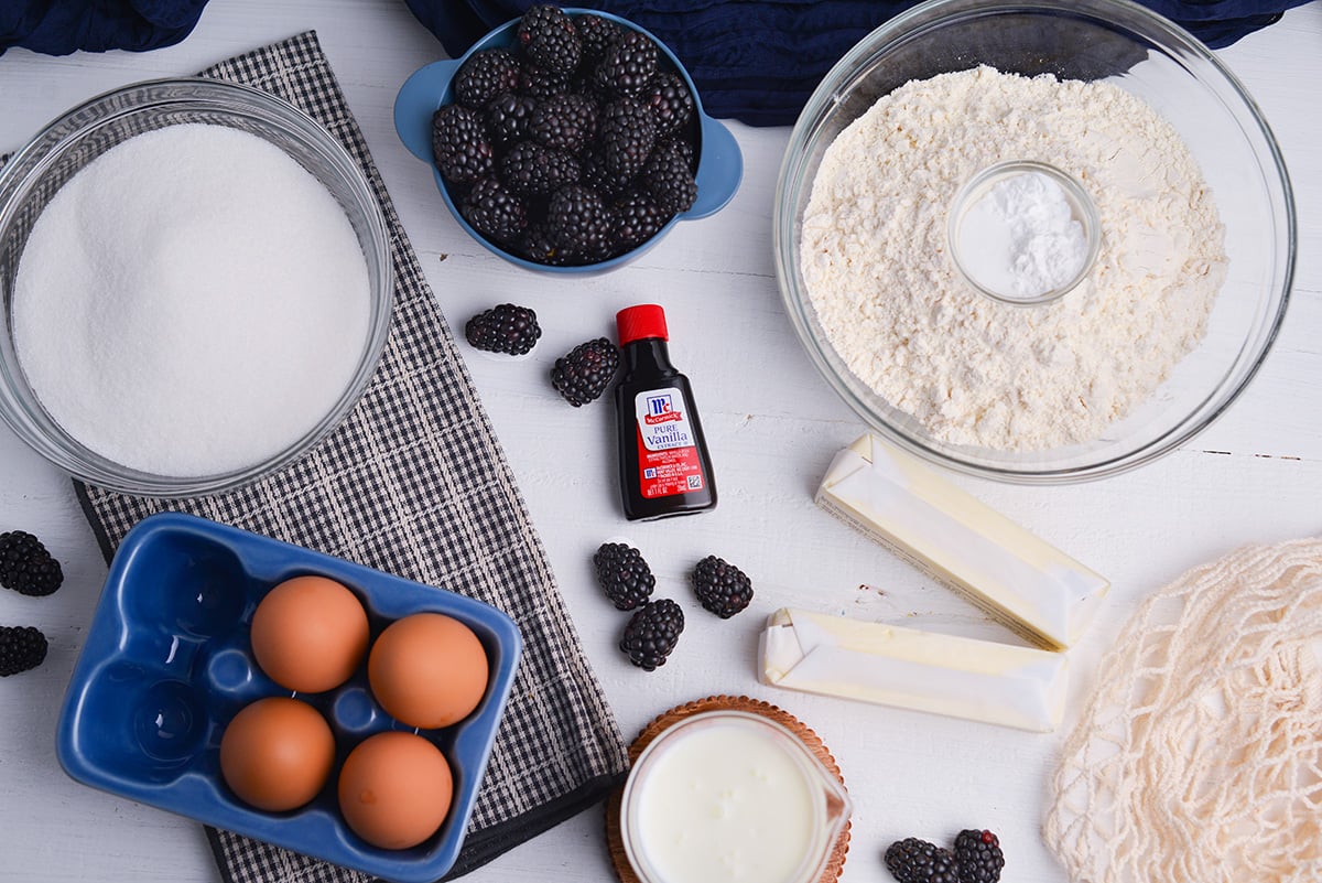 Ingredients for blackberry bundt cake including blackberries, flour, butter, and buttermilk