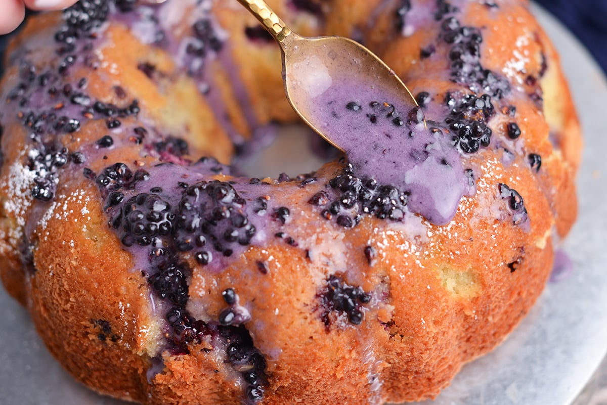 blackberry cake drizzled with blackberry glaze on a plate