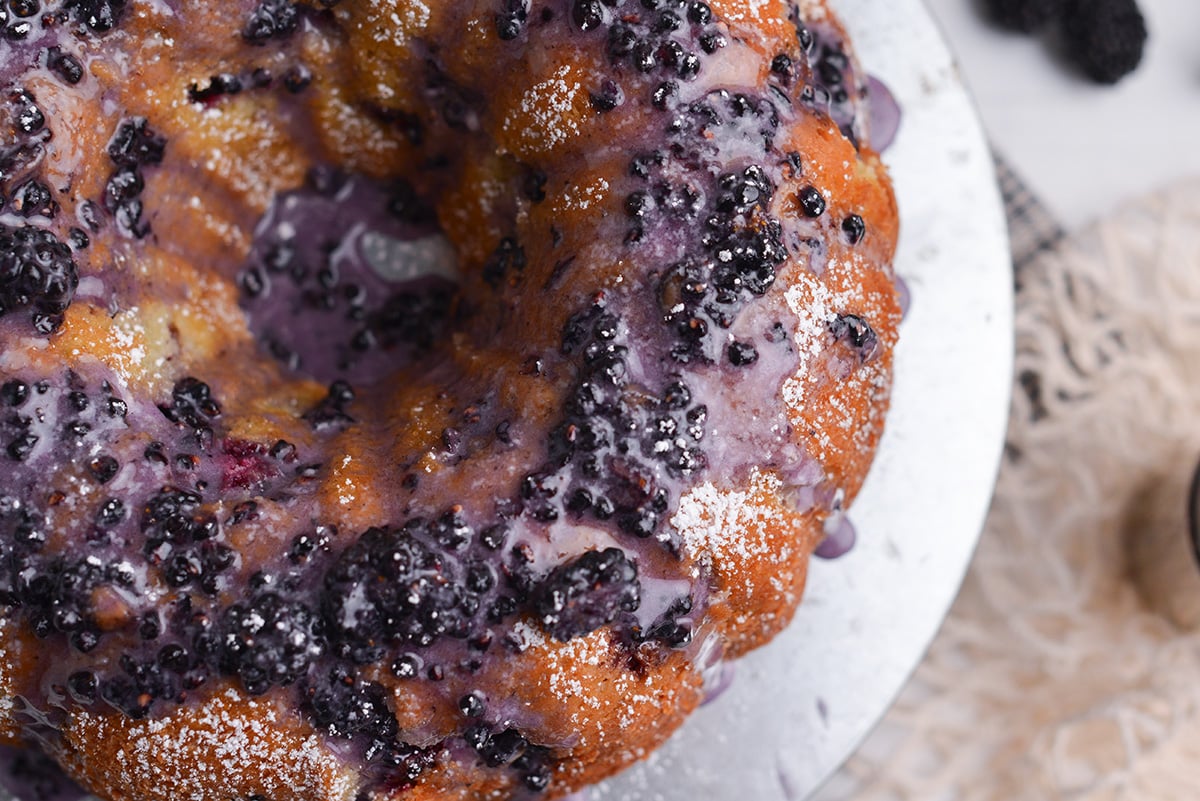 Blackberry bundt cake with blackberry glaze on a cake stand