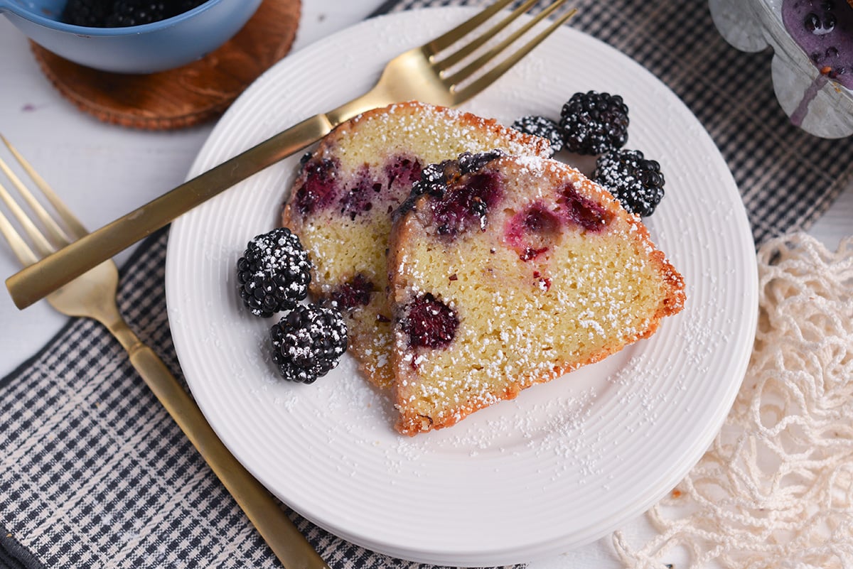 Slice of blackberry cake drizzled with blackberry glaze on a plate