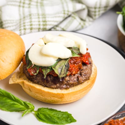 angled shot of open-faced caprese burger on plate