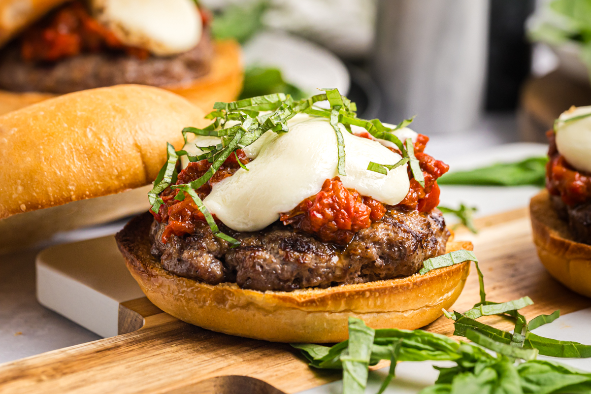 Caprese burger with fresh mozzarella, basil, and sun-dried tomato spread on a toasted bun