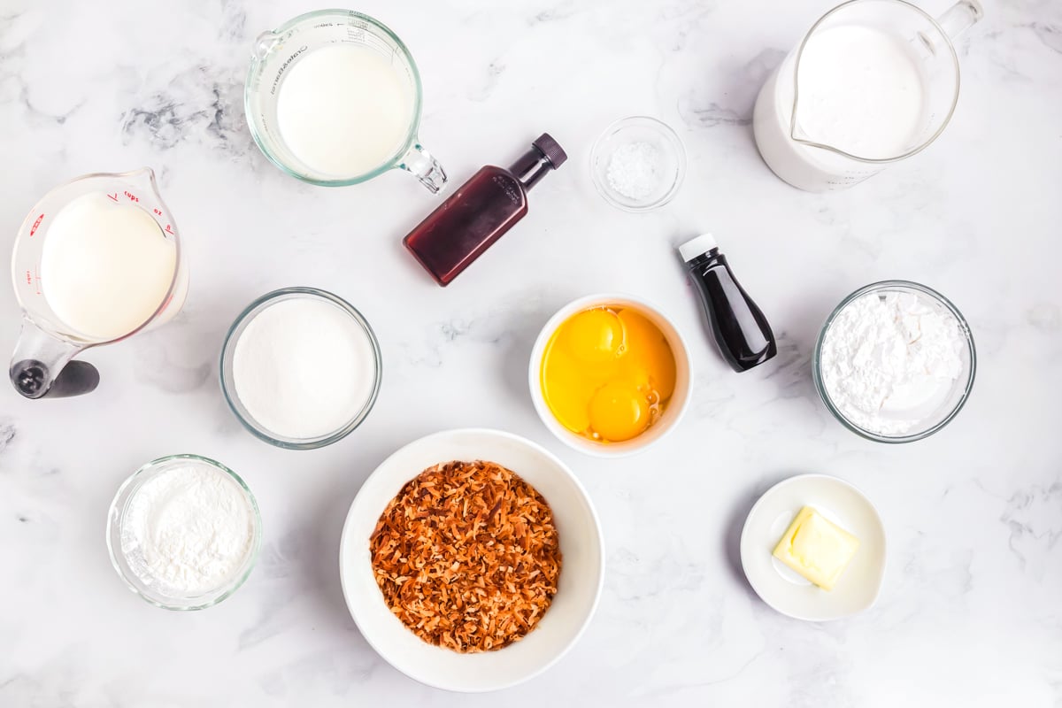 overhead view of coconut cream pie ingredients including coconut milk, cream, and pie crust