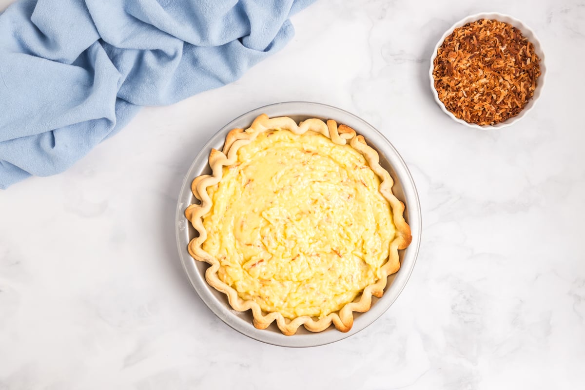 coconut cream pie filling poured into baked pie crust