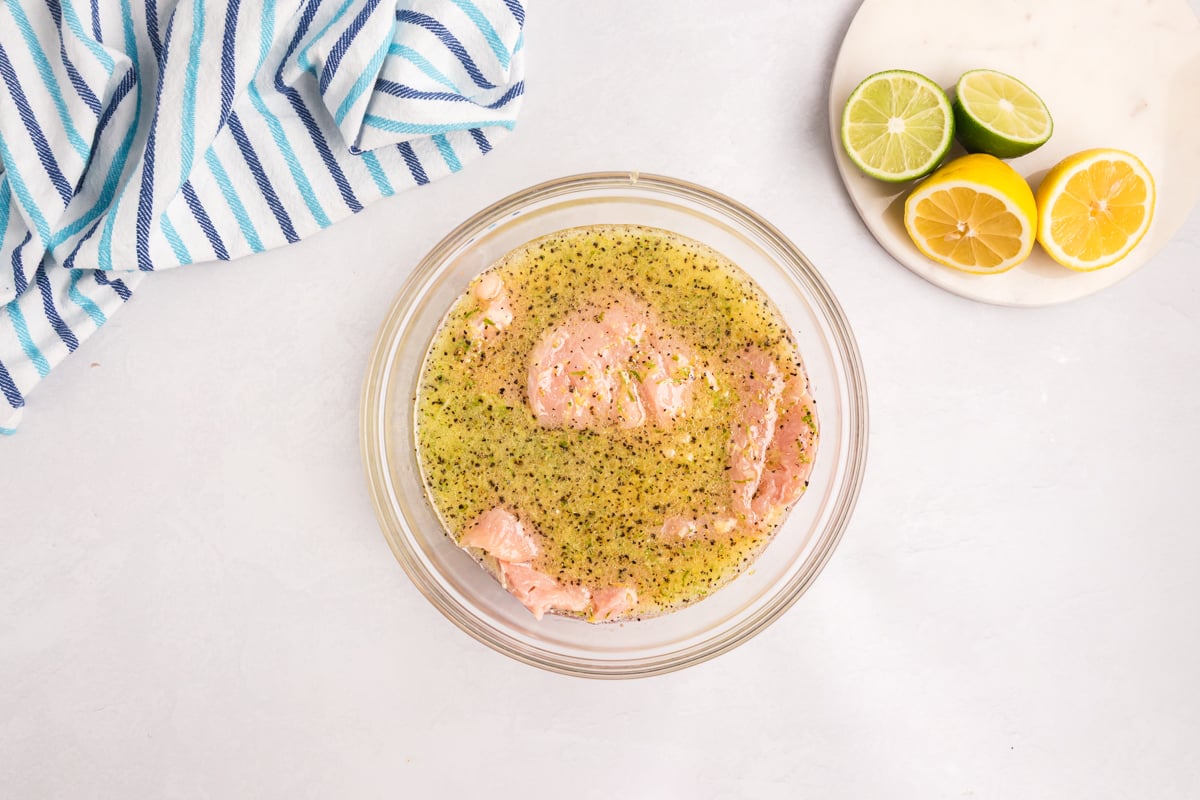 raw chicken breasts in citrus chicken marinade with orange lemon and lime