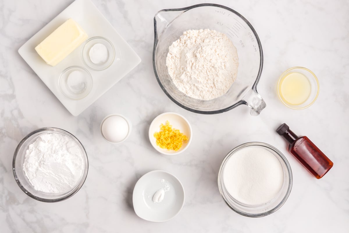 ingredients for lemon cooler cookies including fresh lemon zest juice flour and powdered sugar