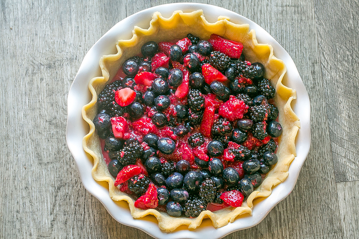 Fresh mixed berry pie filling in an unbaked pie crust before adding crumb topping