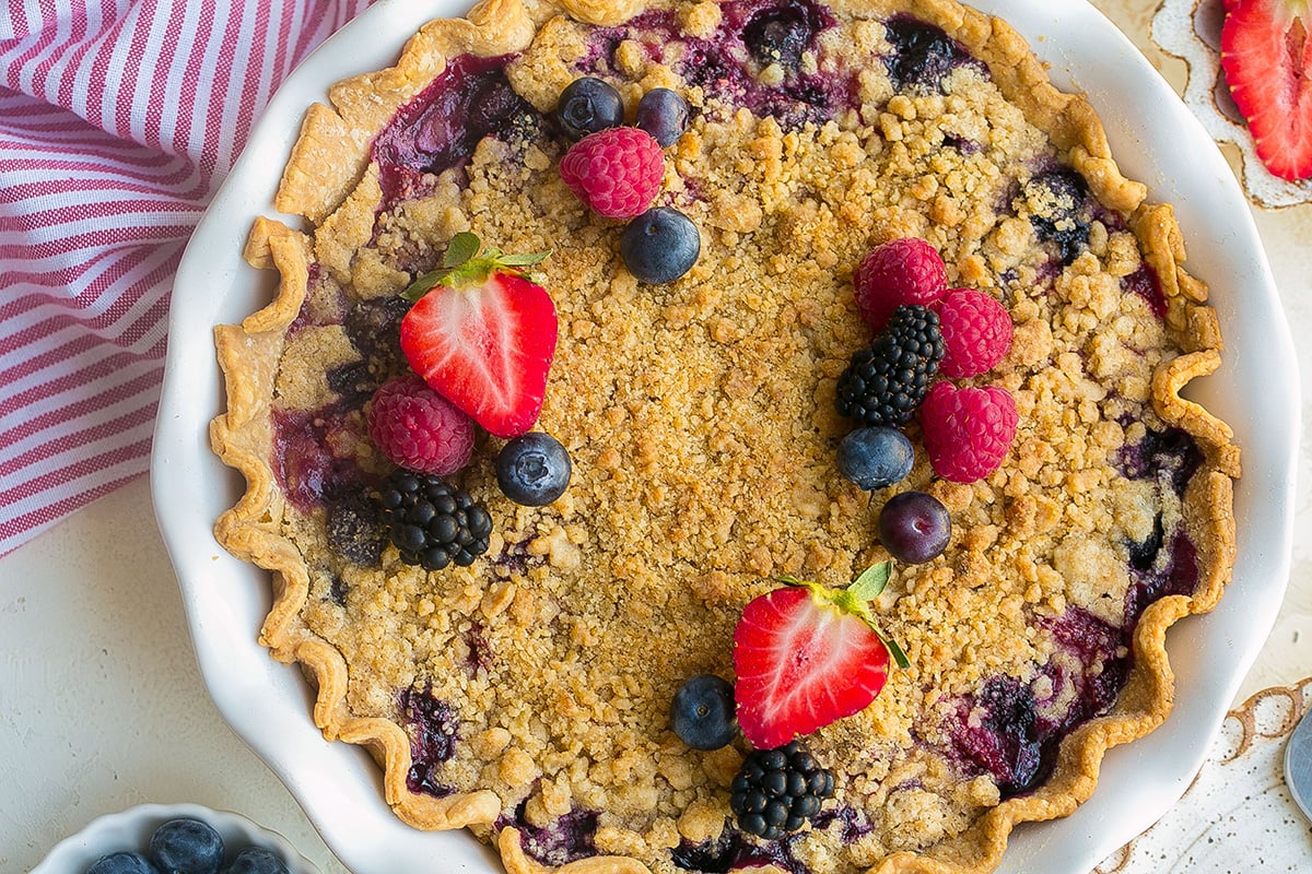 Overhead view of homemade mixed berry pie with golden crumb topping