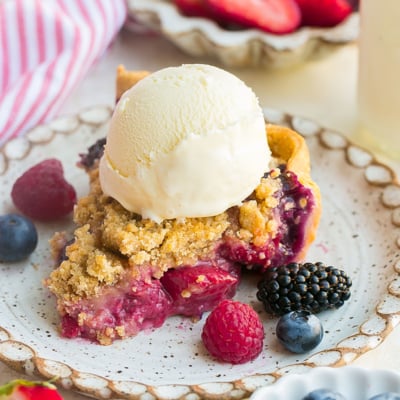 angled shot of slice of pie with ice cream on plate