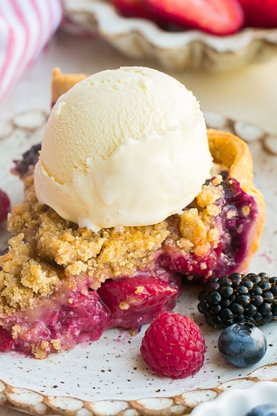 angled shot of slice of pie with ice cream on plate