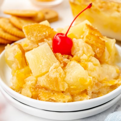 angled shot of plate of pineapple casserole topped with cherry